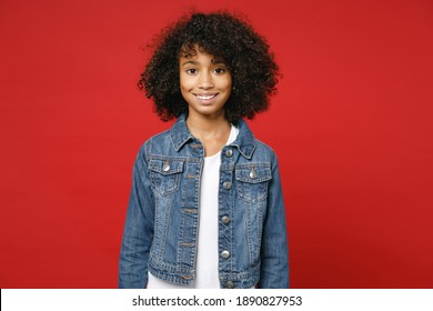 Smiling funny little african american kid girl 12-13 years old wearing casual denim jacket looking camera isolated on bright red color background children studio portrait. Childhood lifestyle concept - Powered by Shutterstock