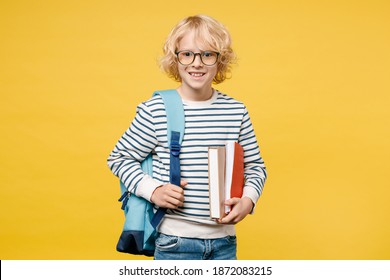 Smiling Funny Little Male Kid Teen Boy 10s Years Old Wearing Striped Sweatshirt Eyeglasses Backpack Holding School Books Isolated On Yellow Color Background, Child Studio Portrait. Education Concept