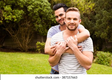 Smiling Gay Couple Hugging In Garden