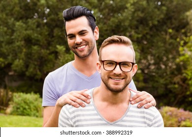 Smiling Gay Couple Hugging In Garden