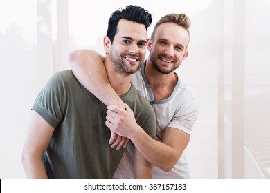 Smiling Gay Couple Hugging At Home