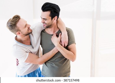 Smiling Gay Couple Hugging At Home