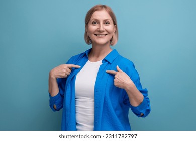 smiling genius blond middle aged woman on blue background with copyspace - Shutterstock ID 2311782797