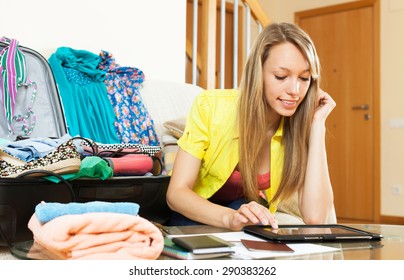 Smiling girl  browsing places to visit with tablet before going on leave