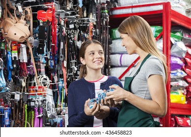 Smiling Girl Buying Toy From Saleswoman In Pet Store