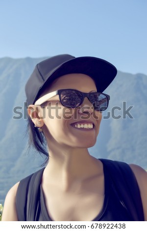 Smiling girl with cap in the mountains
