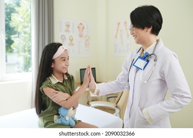 Smiling girl giving high five to pediatrican after getting vaccine in clinic - Powered by Shutterstock