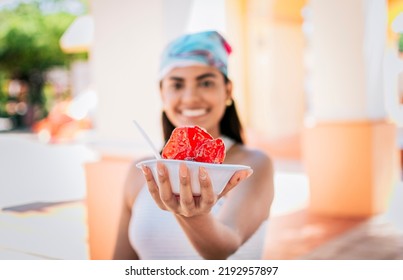 Smiling girl holding shaved ice on the street. Close up of young woman holding a shaved ice in the street. Concept of a girl with a Nicaraguan raspado, Raspado of Nagarote