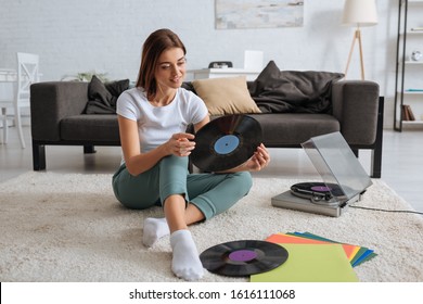 Smiling Girl Holding Vinyl Record While Chilling At Home