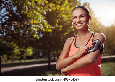 Smiling girl listening to music before training - Powered by Shutterstock