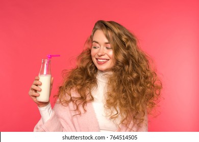 Smiling Girl Looking At Bottle With Milkshake And Plastic Straw Isolated On Red