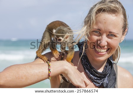 smiling girl with monkey on shoulders
