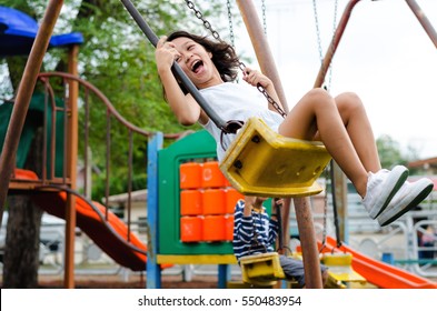 Smiling girl playing on a swing