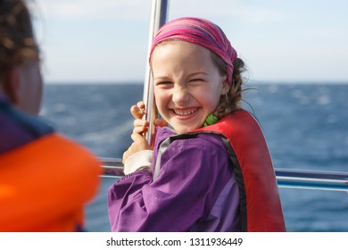 Smiling Girl In Safety Jacket On A Boat Trip. Family On A Blue Whale Watching Trip. 