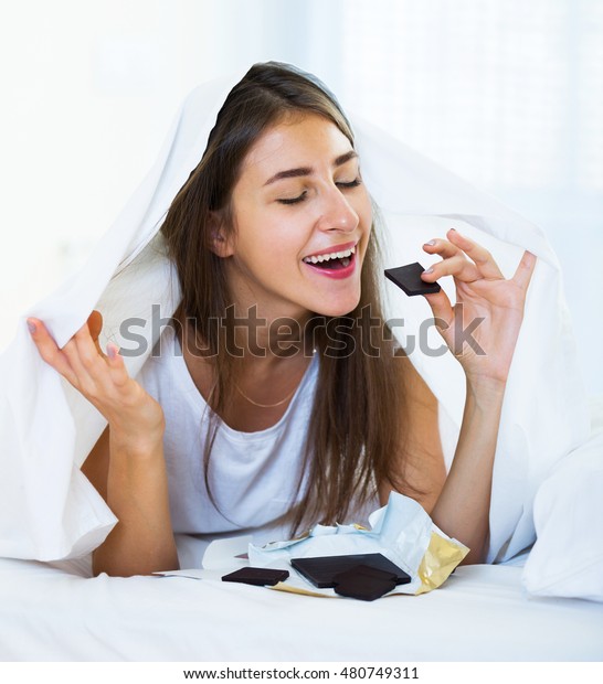 Smiling Girl Secretely Eating Chocolate Under Stock Photo 480749311 ...