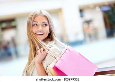 Smiling girl with shopping bags in shop - Powered by Shutterstock