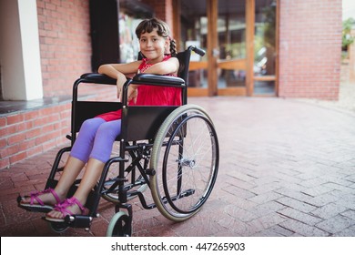 Smiling girl siting in a wheelchair on a sunny day