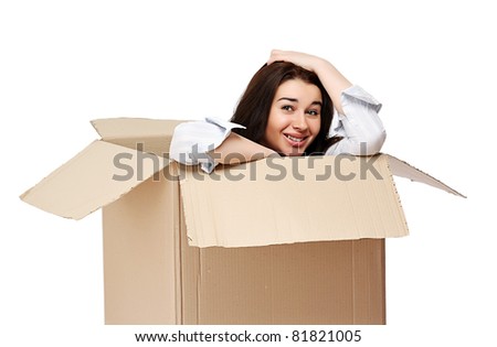 A smiling girl sitting in a cardboard box, isolated on white