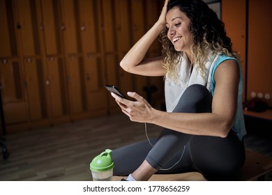 Smiling Girl In A Sports Locker Room  Listen Music On Phone.