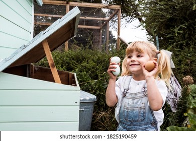 Smiling girl standing outdoors, holding three freshly laid eggs in her hands. - Shutterstock ID 1825190459