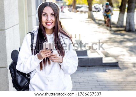 smiling girl student - listening to music - portrait outdoor