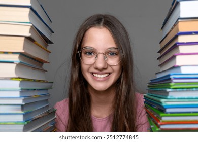 Smiling girl surrounded by stacks of books wearing glasses. A cheerful young girl with long hair and glasses smiles brightly while sitting between two large stacks of books. - Powered by Shutterstock