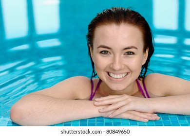 Smiling girl in a swimming pool with copy space