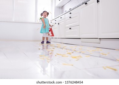 Smiling Girl Throwing French Fries In Kitchen