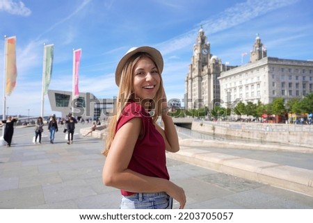 Smiling girl walking in Pier Head riverside in the city centre of Liverpool, England