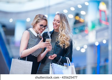 Smiling Girls With Mobile In A Store