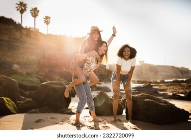 Smiling glad millennial european and african american women students tourists have fun, play game, enjoy summer vacation on beach. Trip, active lifestyle, bachelorette party outdoor - Powered by Shutterstock