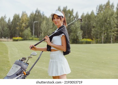 Smiling golfer woman with golf club outdoors on court. Active healthy lifestyle concept - Powered by Shutterstock