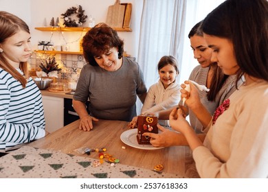 Smiling grandmother with daughter and granddaughters cook Christmas cookies together in kitchen. Mature woman with her cute happy girls decorate gingerbread house with sweets. Family dinner at home. - Powered by Shutterstock