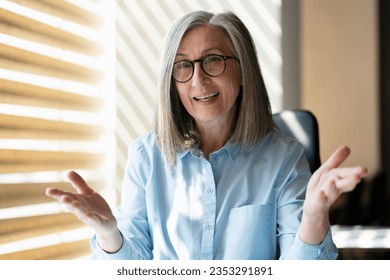 Smiling gray haired businesswoman talking, explaining something having video call. Confident teacher communication, online education concept. Video conference  - Powered by Shutterstock