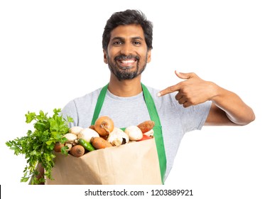 Smiling Grocery Store Or Supermarket Employee Presenting Fresh Products In Paper Bag With Index Finger Isolated On White