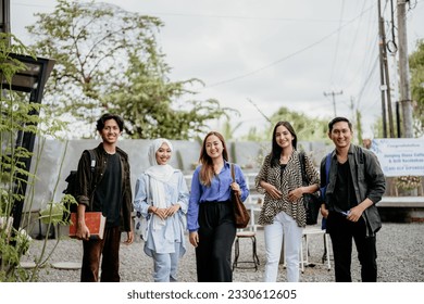 smiling group of Asian students standing in an outdoor coworking space