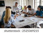 Smiling group of diverse businesspeople working together around a meeting table in an office