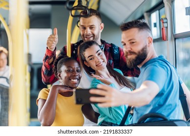 Smiling group of diverse friends riding together on a bus and taking selfie with a smartphone. Multiracial group of people enjoying travel or ride on public vehicle and having fun. - Powered by Shutterstock