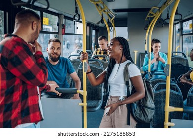 Smiling group of diverse friends riding together on a bus. Multiracial group of people enjoying travel or ride on public vehicle and having a conversation. Students using public transportation. - Powered by Shutterstock