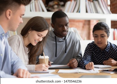 Smiling group of diverse students preparing for seminar or session together. Indian female teammate explaining home task for african american concentrated guy. Positive college friends doing homework. - Shutterstock ID 1470546236
