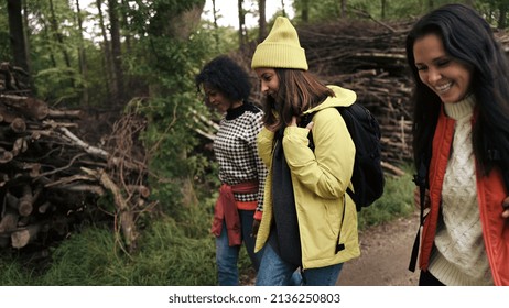 Smiling Group Of Diverse Young Female Friends In Hiking Gear Walking Together Along A Path In A Forest