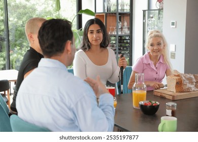 Smiling group of friends making breakfast together in modern kitchen - Powered by Shutterstock