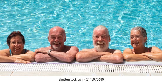 Smiling Group Of Senior People In Swimming Pool Enjoying The Summer And Retirement. Happiness Under The Bright Sun. Blue Transparent Water