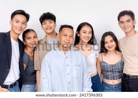Smiling group of six young people with their elder mentor or teacher standing together, posing on a white background.