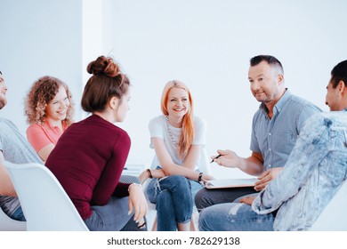 Lächelnde Gruppe von Teenagern während eines Treffens mit Persönlichkeitstrainer hilft ihnen, Selbstvertrauen zu gewinnen