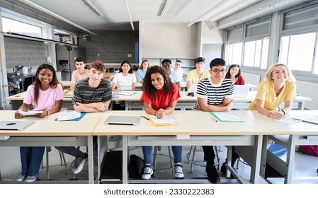 Smiling group of university college sitting at classroom looking at camera. Portrait of cheerful Students of high school. study together. People, education and community people. High quality photo - Powered by Shutterstock