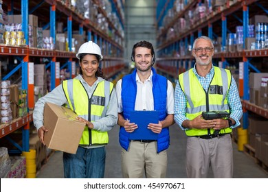 Smiling group of workers looking at camera in warehouse