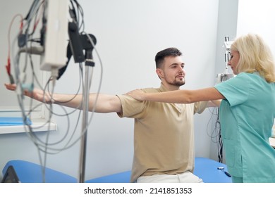 Smiling Guy Moving Arms In Neurologist Office