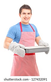 Smiling Guy  Wearing Cooking Mittens And Apron Holding A Baking Tray Isolated On White Background