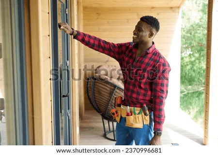 Smiling guy with work tools is knocking on the door
